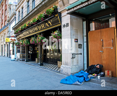 Senzatetto uomo addormentato al di fuori di un pub, Holborn, Londra, Inghilterra, Regno Unito Foto Stock