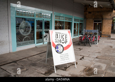 Negozio di noleggio della bicicletta, con ciclo di stand, vicino alla stazione della linea principale stazione ferroviaria della città di York, nello Yorkshire, Inghilterra, Regno Unito Foto Stock