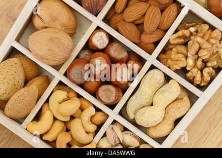 Selezione di noci e mandorle in scomparti di legno Foto Stock