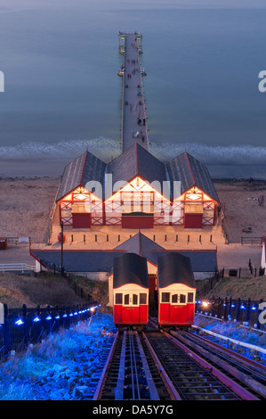 Serata estiva alta vista su Saltburn illuminata di sollevamento sulla scogliera, la gente che camminava sul molo vittoriano e la calma del mare del Nord - Cambs, Inghilterra, Regno Unito. Foto Stock