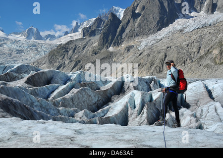Una donna scalatore attraversa una caduta di ghiaccio sul massiccio del Monte Bianco al di sopra di Chamonix in Francia Foto Stock
