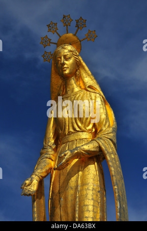 Oro bella statua della Vergine Maria in piedi sulla parte superiore di un antico passano tra Italia e Svizzera. l'alone containi Foto Stock