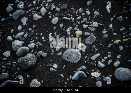 Pietre di basalto nero in sabbia di lava Foto Stock