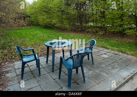Un tavolo di plastica e sedie in autunno nel giardino vicino a casa di  paese Foto stock - Alamy