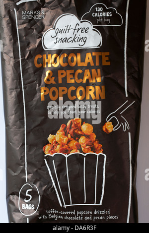 Borsa multipack di 5 sacchi di colpevolezza libera snacking di Marks & Spencer Cioccolato & Popcorn alle noci pecan Foto Stock