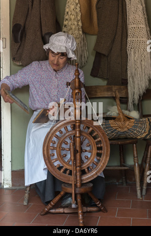 Una donna in costume vittoriano mano la filatura della lana a Acton Scott storica fattoria di lavoro. Shropshire. Regno Unito Foto Stock