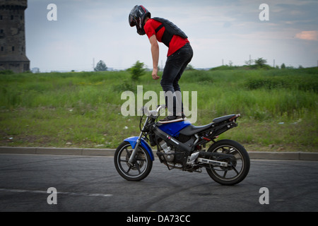 Stunt di motociclisti che praticano la loro abilità su strada vuota. Katowice in Polonia. Foto Stock