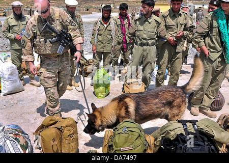 Un esercito USA gestore del cane con Cougar Compagnia del 101st Airborne controlla i sacchetti di Afghan Air Force reclute prima di salire a bordo dell aeromobile Giugno 2, 2013 in Bastik FOB, Kunar Provincia, Afghanistan. Foto Stock