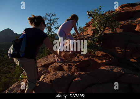 Giugno 9, 2013 - Sedona, in Arizona, Stati Uniti - Madre e figlia escursione prima del tramonto all'Aeroporto di Sedona sito vortex. Il fascino di Sedona siti Vortex. Molte persone visitare Sedona per esplorare la sua dimensione metafisica, soprattutto i suoi vortici. Pagina Bryant ha coniato il nome "vortice" nel 1980 per le aree in Sedona che sono altamente concentrato energie favorevole alla preghiera, la meditazione e la guarigione. Sedona attrazione principale è la sua schiera di pietra arenaria rossa formazioni, che sembrano glow in brillante arancio e rosso quando è illuminata dalla crescente o impostazione di sun. Le rocce rosse formano un sfondo popolare per molti o Foto Stock