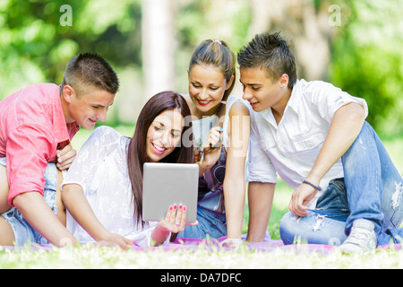 Gli adolescenti nel parco con la compressa Foto Stock