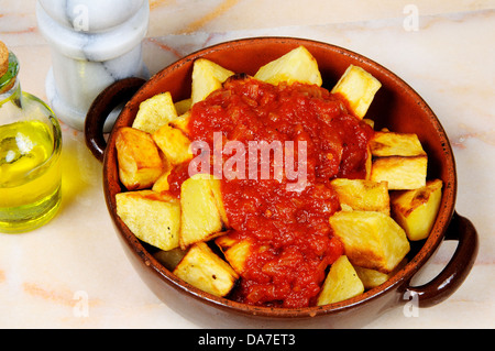 Tapas spagnole di Patatas bianche su un tavolo di marmo (superiore scheggiato le patate in una piccante salsa di pomodoro). Foto Stock