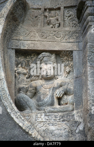 Grotta n. 26 : seduti Yaksha figura con altamente corona ornata sul chaitya arco della grotta. circa 5th. Secolo D.C. Ajanta Foto Stock