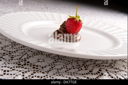 Seduta di fragole al cioccolato swirl sulla piastra bianca Foto Stock