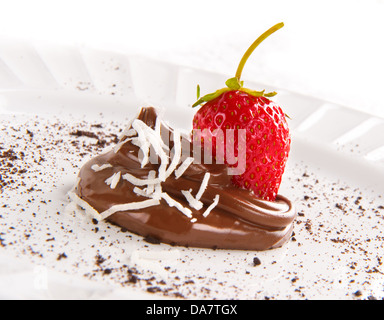 Seduta di fragole al cioccolato swirl con spinkles con scaglie di noce di cocco sulla piastra bianca in primo piano Foto Stock