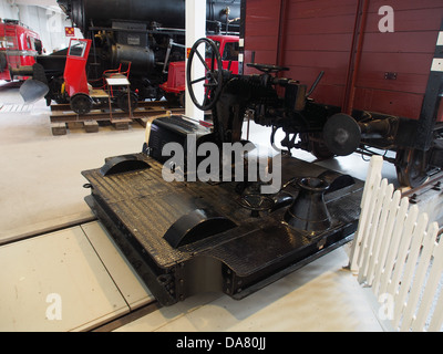 Questa immagine presenta una locomotiva nera molto vecchia, un tipo di motore ferroviario utilizzato per spostare le auto all'interno dei cantieri ferroviari. La locomotiva, parte di una prima collezione di motori a vapore, mostra l'evoluzione del trasporto ferroviario. Foto Stock