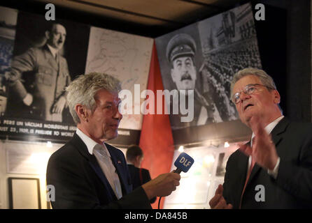 Riga, Lettonia. 07 Luglio, 2013. Il Presidente tedesco Joachim Gauck dà una intervista radio presso il Museo di occupazione in Riga, Lettonia, 07 luglio 2013. Ritratti di dittatori sovietico Joseph Stalin e dittatore tedesco Adolf Hitler (L) appendere in background. Foto: WOLFGANG KUMM/dpa/Alamy Live News Foto Stock