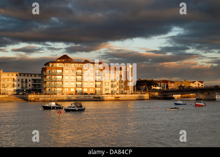 Nel tardo pomeriggio sun mette in evidenza uno sviluppo del waterfront homes accanto al fiume Adur nel West Sussex, in Inghilterra del sud. Foto Stock