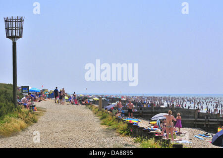 West Wittering, West Sussex, Regno Unito. 7 Luglio, 2013. Sizzling la domenica come giorno di gitanti prendere per il popolare West Wittering spiaggia per rinfrescarsi come le temperature sono aumentate a 30 gradi della navigazione nel sud dell Inghilterra seconda auto park aperto in grado di accogliere fino a 10.000 vetture. iphone ipad sono state presso il pronto per lo streaming del Wimbledon Tennis, spiaggia sotto le tende e sotto gli ombrelloni Foto Stock