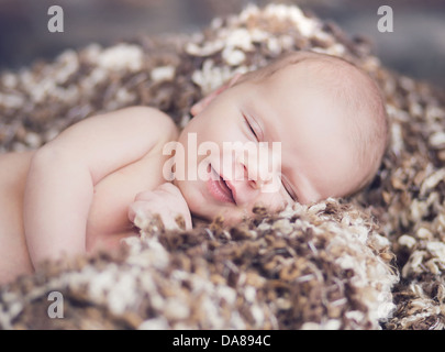 Carino adorabile neonato bimbo avvolto o swaddle in una coperta, dormire e  talvolta entrambi gli occhi aperti in letto per bambini Foto stock - Alamy