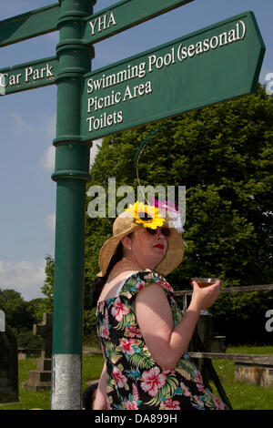 Un cartello stradale per diverse destinazioni in Ingleton, UK. 7 Luglio, 2013. Nikki godendo di sale ristoro al funzionamento HomeGuard, Ingleton's 1940's weekend quando Ingleton divenne il Tedesco Francese occupato città mercato di La Chapell-De-Marais liberata dal re-enactors. Foto Stock