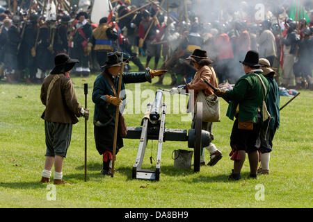 Chippenham, Wiltshire. 7 Luglio, 2013. Guerra Civile Inglese Società membri preparare per caricare e sparare un cannone come la battaglia continua di fronte a loro.Essi sono stati rivivere la battaglia per Chippenham che ha avuto luogo durante la guerra civile inglese nel 1643. Credito: lynchpics/Alamy Live News Foto Stock