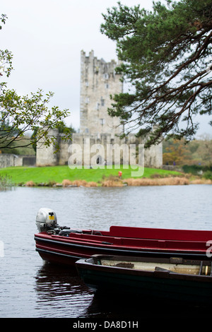 Una barca di legno a noleggio per escursioni intorno a Lough Leane è legato accanto al Castello di Ross vicino a Killarney in Repubblica di Irlanda Foto Stock