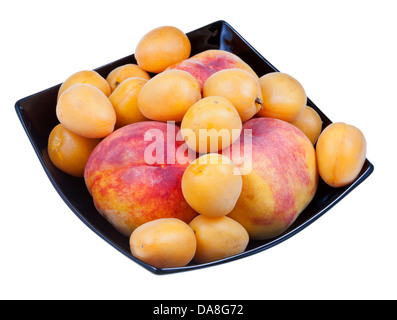 Pesche fresche e le albicocche in piastra nera isolati su sfondo bianco Foto Stock