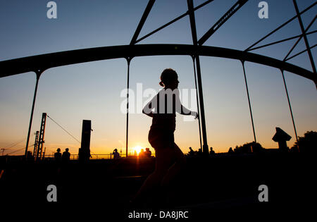 Una donna fa avanzare durante il tramonto sul ponte Modersohnbruecke a Berlino, Germania, 07 luglio 2013. Foto: MARCEL KUSCH Foto Stock