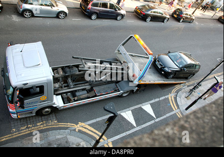 Ripartiti in auto essendo winched sul caricatore basso recupero veicolo, Londra Foto Stock