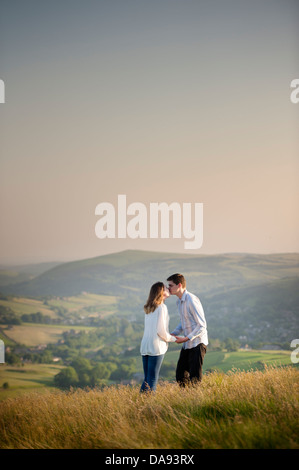 Coppia giovane baciando su una collina Foto Stock