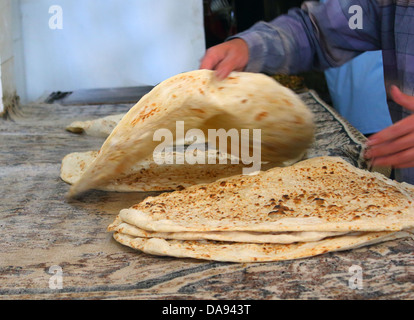 Arab baker rendendo pane arabo . Foto Stock