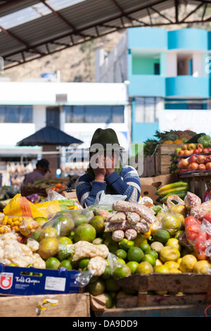 Una donna locale nasconde la sua faccia da un fotografo in piedi di fronte al mercato settimanale Pujili Quilotoa regione dell'Ecuador Foto Stock