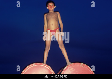 Gli Yanomami ragazzo nativo sorge su esercito brasiliano di galloni di carburante. Presenza dell'Esercito del popolo indigeno territorio Amazon Foto Stock