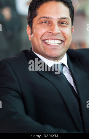Ritratto di felice commerciante indiano in abito nero Foto Stock
