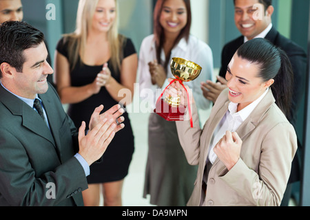 Bella femmina allegro Lavoratore aziendale di ricevere un trofeo dal CEO società Foto Stock