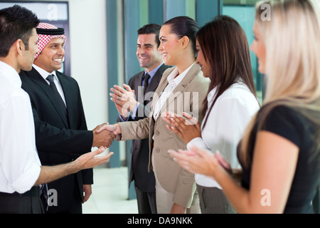 Traduttore giovani introducendo imprenditore arabo al gruppo di imprenditori Foto Stock