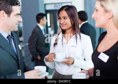 Gli imprenditori che interagiscono durante la pausa caffè presso conferenze di affari Foto Stock