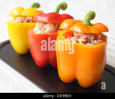 Un colorato trio di peperoni ripieni di riso, i funghi e i pomodori. Foto Stock