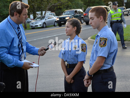 Un TV reorter interviste due cadetti di polizia al funerale di un poliziotto ucciso nella linea del dazio Beltsville, Maryland Foto Stock