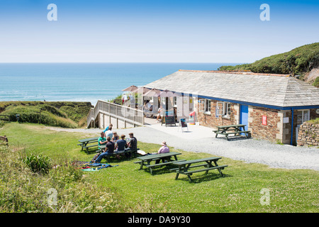 Persone per godersi il sole e il caldo presso il cafe da Sandymouth Bay sulla North Devon Coast. Foto Stock