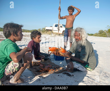 Guida aborigena Brian Lee e ragazzi indigeni a fuoco di campo dell'entroterra di Capo Leveque cottura granchio del fango Foto Stock