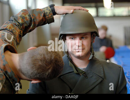 Un file immagine datata 05 aprile 2005 mostra un istruttore delle forze armate tedesche verificando le dimensioni di un casco di reclutare presso il feldmaresciallo Rommel caserme in Alsdorf, Germania. Dopo più di cinquanta anni di coscrizione, uomini per assumere il loro obbligo di prestare servizio militare per l'ultima volta il 03 gennaio 2011, a causa delle riforme delle forze armate tedesche piano per mettere il servizio nazionale per un fine da 0 Foto Stock