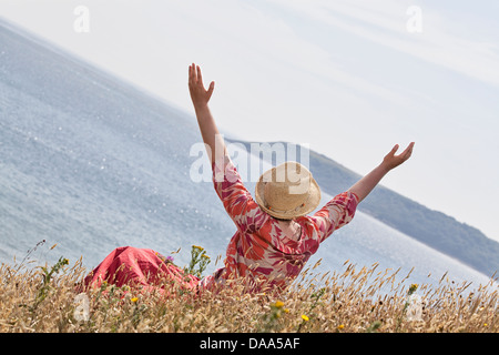 Donna con le mani alzate verso il cielo Foto Stock