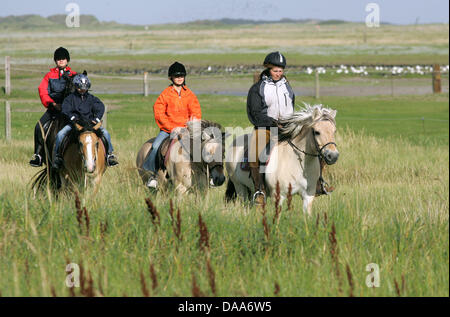 Un file immagine datata 26 agosto 2005 mostra i turisti a cavallo sull'isola di Juist, Germania. Il Nord-ovest della Germania offre abbondanza di spazio per attività salutari per i turisti. Foto: Ingo Wagner Foto Stock