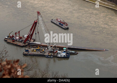 Forze di soccorso praticare dei fori nella murata della nave del rovesciamento chiatta acido per prelevare campioni del carico sul fiume Reno vicino a St Goarshausen, Germania, 28 gennaio 2011. Prima analisi mostra che altamente infiammabile di gas di idrogeno ha dimostrato in nave. I soccorritori sono il pompaggio di azoto nel serbatoio per rendere l'idrogeno innocuo. Foto: THOMAS FREY Foto Stock