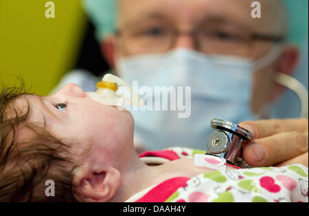 Il dott. Hans Gerd Kehl, il commissionary capo dei figli di cardiologia, controlli sull'operato a 6 settimane-vecchio Ljuah Ahmeti a bambini di cardiologia l'Ospedale Universitario di Muenster, Germania, 10 dicembre 2010. La bambina è nata con un coarctation dell'aorta. Ogni anno, 6000 bambini con difetti cardiaci sono nati in Germania. La possibilità di sopravvivenza per le giovani pazienti Foto Stock