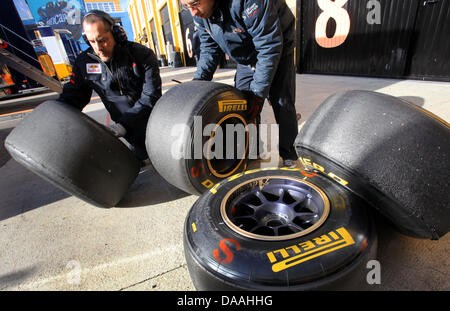 Mechanists della Toro Rosso preparare nuovi pneumatici Pirelli durante una corsa di prova in pista a Valencia, Spagna, 02 febbraio 2011. Il team di Formula Uno prova le loro nuove vetture e pneumatici per la stagione 2011 fino al 03 febbraio 2011. Foto: Jens Buettner Foto Stock