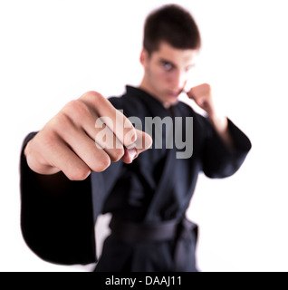 Un uomo che fa kickboxing e gettando un punzone. Messa a fuoco su un pugno. Foto Stock