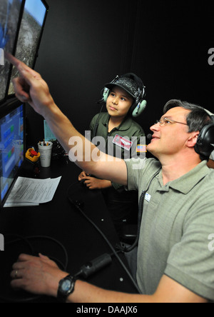 Michael Adams, CAE boom operatore istruttore, mostra Esmeralda Quinonez-Jauregui, 11-anno-vecchio superstite di leucemia, come regolare le condizioni meteorologiche per una KC-135 Stratotanker boom operatore Weapon System Trainer, Giugno 27, 2013, a McConnell Air Force Base, Kan. Foto Stock