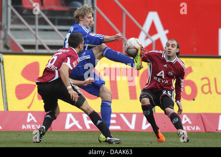 Norimberga Dominic Maroh (L) e Javier Pinola (Argentina, R) il sistema VIES per la palla con il Leverkusen Stefan Kiessling durante il tedesco Bundeliga match 1. FC Norimberga vs Bayer 04 Leverkusen a easyCredit stadium di Norimberga in Germania, 05 febbraio 2011. Foto: DANIEL KARMANN (ATTENZIONE: embargo condizioni! Il DFL consentire l'ulteriore utilizzazione delle immagini nella IPTV, mobile ser Foto Stock